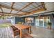 A back porch with wooden table, chairs, and outdoor ceiling fan at 8448 Se 161St St, Summerfield, FL 34491