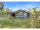 The back exterior of a grey home featuring a back porch and backyard at 8448 Se 161St St, Summerfield, FL 34491