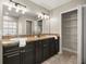 Bathroom with dual sinks, granite countertops, and dark wood cabinetry at 8448 Se 161St St, Summerfield, FL 34491