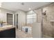 Bathroom featuring a separate tub and glass shower, window, and storage closet at 8448 Se 161St St, Summerfield, FL 34491