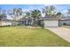 Charming single-story home with well-manicured lawn, palm tree, and an attached two car garage at 8448 Se 161St St, Summerfield, FL 34491