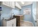 Well lit laundry room featuring a utility sink, countertop, and wall cabinets at 8448 Se 161St St, Summerfield, FL 34491