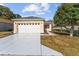 Inviting one-story home featuring a wide driveway, a two-car garage, and lovely landscaping at 9464 Se 132Nd Loop, Summerfield, FL 34491