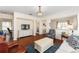 Cozy living room featuring hardwood floors, a decorative chandelier, and a TV at 9464 Se 132Nd Loop, Summerfield, FL 34491