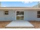 Back of home with a glass sliding door leading to a small patio, perfect for outdoor relaxation at 10162 Sw 137 Ave, Dunnellon, FL 34432