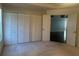 Carpeted bedroom featuring ample closet space, natural light, and an open doorway to another room at 10819 Sw 84Th Ter, Ocala, FL 34481