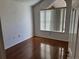 Bright bedroom featuring hardwood floors and a large window with pleated blinds for natural light at 10819 Sw 84Th Ter, Ocala, FL 34481