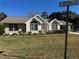 Charming home with arched windows, a well-manicured lawn, and attractive landscaping at 10819 Sw 84Th Ter, Ocala, FL 34481