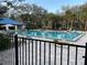 Community pool with a blue tile, surrounded by lounge chairs and palm trees at 10819 Sw 84Th Ter, Ocala, FL 34481