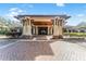 Stunning clubhouse entrance with stone accents, brick pavers, and a covered portico for convenient arrival at 31771 Red Tail Blvd, Sorrento, FL 32776