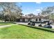 Clubhouse exterior featuring well-manicured landscaping and multiple golf carts at 31771 Red Tail Blvd, Sorrento, FL 32776