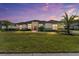 Spacious single-story home featuring manicured lawn, tropical palms, and neutral stucco with stone accents at 31771 Red Tail Blvd, Sorrento, FL 32776