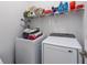 Efficient laundry room with modern washer and dryer, wire shelving, and organized storage containers at 31771 Red Tail Blvd, Sorrento, FL 32776