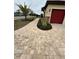 Paver walkway and lush landscaping leading to a well-maintained home with a red garage door at 31771 Red Tail Blvd, Sorrento, FL 32776