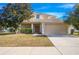 Two-story house with tan exterior, attached garage, and landscaping at 3921 Sw 51St Ter, Ocala, FL 34474