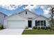 Charming single-story home boasts a well-manicured lawn, a two-car garage, and navy blue shutters and front door at 8465 Las Palmas Way, Wildwood, FL 34785