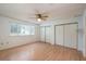 Bright bedroom with wood floors, a ceiling fan and double sliding doors to closet at 8475 Sw 109Th Lane Rd, Ocala, FL 34481