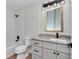 Updated bathroom boasts a tiled tub, modern vanity with granite countertop, and stylish lighting at 3496 Sw 149Th Ct, Ocala, FL 34481