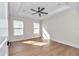 Bright bedroom with tray ceiling, hardwood floors, and natural light from two windows at 3496 Sw 149Th Ct, Ocala, FL 34481