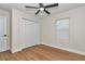 This neutral bedroom features wood floors, a window, a closet, and modern ceiling fan at 3496 Sw 149Th Ct, Ocala, FL 34481