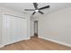 Bright bedroom with wood flooring features closet space and a modern ceiling fan at 3496 Sw 149Th Ct, Ocala, FL 34481