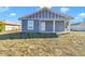 Gray house with white trim and a covered porch, showcasing curb appeal at 3496 Sw 149Th Ct, Ocala, FL 34481