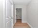 Clean hallway view with neutral walls and hardwood floors, showing an open doorway to laundry at 3496 Sw 149Th Ct, Ocala, FL 34481