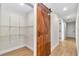 Hallway features a stylish sliding wooden barn door, providing access to a storage area at 3496 Sw 149Th Ct, Ocala, FL 34481