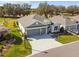 Aerial view of the home showcasing its three-car garage, manicured lawn, and well-kept landscaping at 4522 Shockoe Cir, The Villages, FL 32163