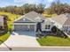 Exterior aerial view of a charming single-story home with well-manicured landscaping and a three-car garage at 4522 Shockoe Cir, The Villages, FL 32163