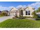 Inviting one-story home featuring a three-car garage, well-maintained lawn, and tidy garden bed at 4522 Shockoe Cir, The Villages, FL 32163