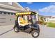 Stylish golf cart parked in front of the house, featuring a yellow and white striped canopy and comfortable seating at 4522 Shockoe Cir, The Villages, FL 32163