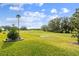 Scenic golf course view showcasing lush green fairways and a sand trap under a bright blue sky with scattered clouds at 4522 Shockoe Cir, The Villages, FL 32163