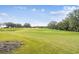 Scenic view of a meticulously maintained golf course with lush green fairways and mature trees under a blue sky at 4522 Shockoe Cir, The Villages, FL 32163