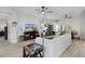 Open living room with light wood-look floors, comfortable seating, and a view into the dining area at 4522 Shockoe Cir, The Villages, FL 32163