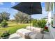 Outdoor patio featuring cushioned lounge chairs under a large umbrella with lush green golf course views at 4522 Shockoe Cir, The Villages, FL 32163