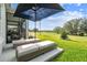 Outdoor patio featuring cushioned lounge chairs under an umbrella overlooking the green golf course at 4522 Shockoe Cir, The Villages, FL 32163