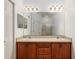 Double vanity bathroom with wood cabinets and large mirror at 7947 Sw 80Th Place Rd, Ocala, FL 34476