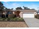 Single-story house with a white garage door and neatly landscaped yard at 7947 Sw 80Th Place Rd, Ocala, FL 34476