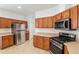 Kitchen with stainless steel refrigerator and wood cabinets at 7947 Sw 80Th Place Rd, Ocala, FL 34476