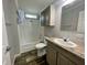 Bright bathroom featuring a shower-tub combo, neutral vanity with storage, and wood-look flooring at 11605 Nw 20Th St, Ocala, FL 34482