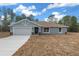 Newly constructed home with light blue exterior, attached garage, and driveway at 8436 Sw 136Th Ter, Dunnellon, FL 34432