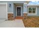 Front entrance with dark gray door and stone accents at 8436 Sw 136Th Ter, Dunnellon, FL 34432