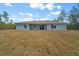 Rear view of a single-story house with sliding glass doors and a large backyard at 8436 Sw 136Th Ter, Dunnellon, FL 34432