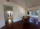 Dining area with wood floors, chandelier, and a view into the sunroom at 8968 Sw 116Th Place Rd, Ocala, FL 34481