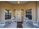 Inviting front porch with white chairs and a brown welcome mat at 21 Fisher Trail Pass, Ocklawaha, FL 32179