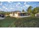 Back exterior view showing a house with a screened porch and storage building at 21 Fisher Trail Pass, Ocklawaha, FL 32179