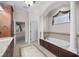 Bathroom with a garden tub, vanity with dual sinks, and an arched entry at 3907 Se 10Th Ave, Ocala, FL 34480