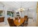 Open-concept dining area featuring tile floors, modern chandelier, and views of the pool area at 3907 Se 10Th Ave, Ocala, FL 34480