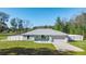 Newly built home with light teal exterior, white fence, and a two-car garage at 14462 Se 28Th Ct, Summerfield, FL 34491